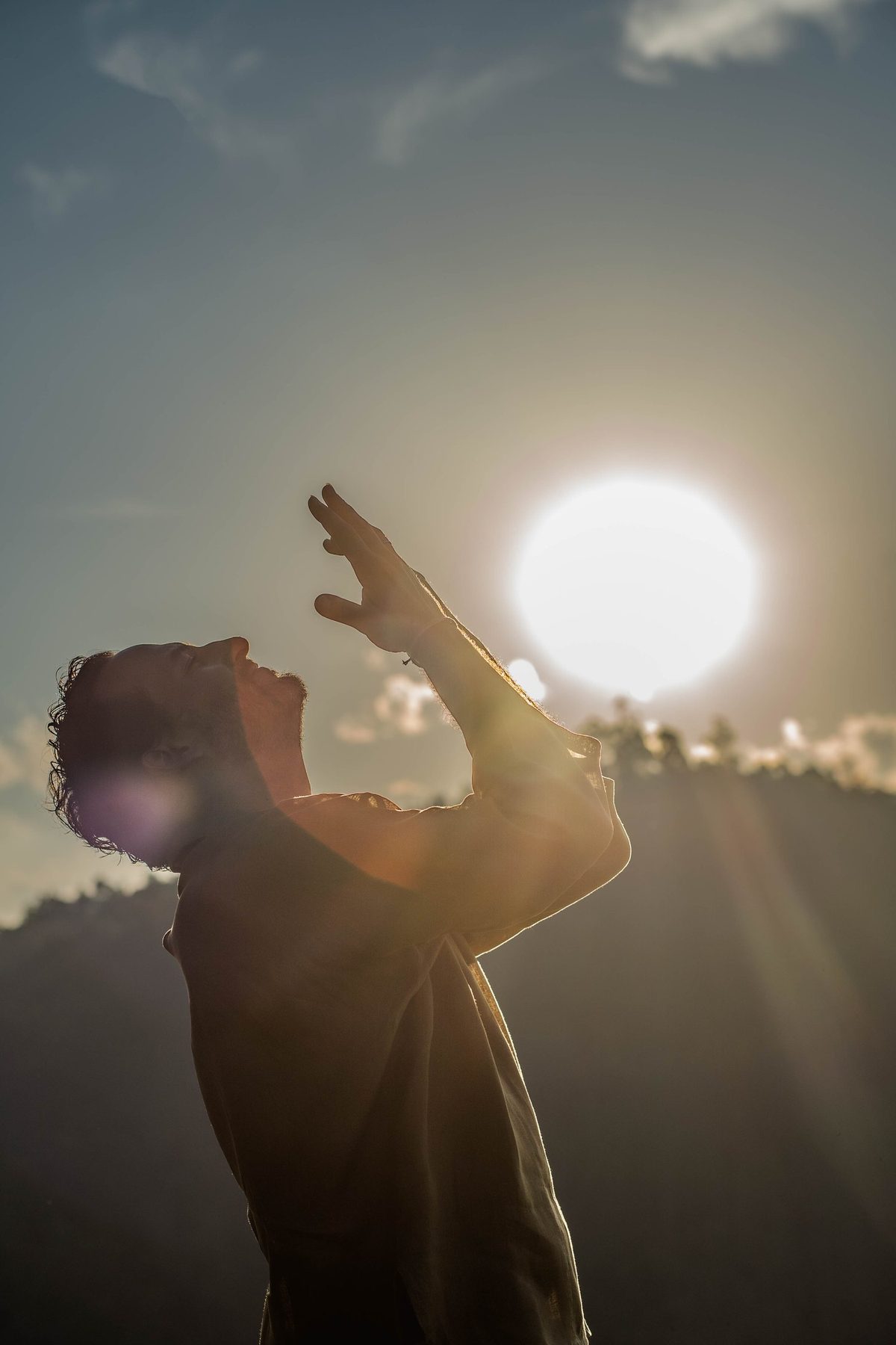 Rael Luz de perfil, com as mãos erguidas em direção ao sol